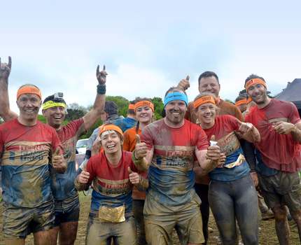 A group of mud run participants standing together after the race